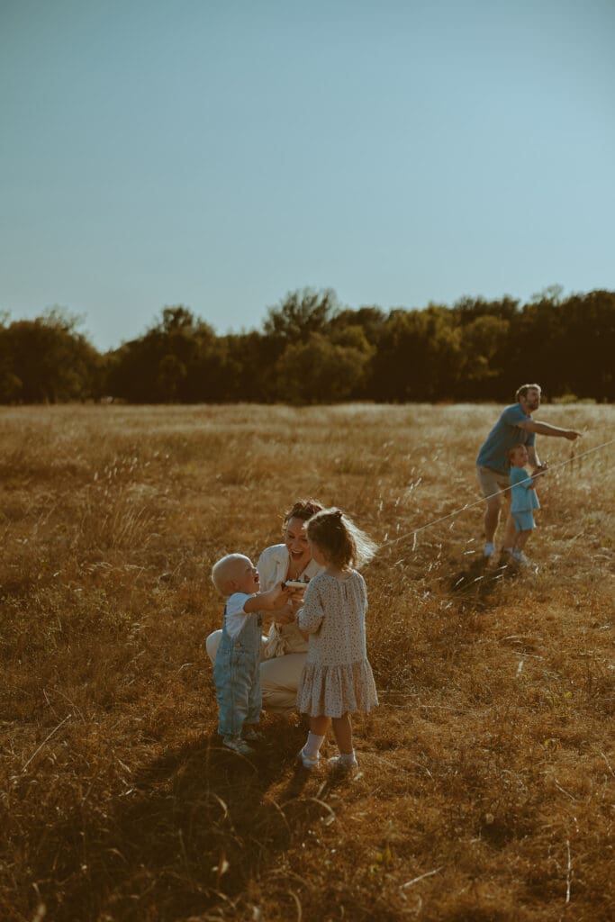 Playful family session flying kites in a field in Abilene, TX