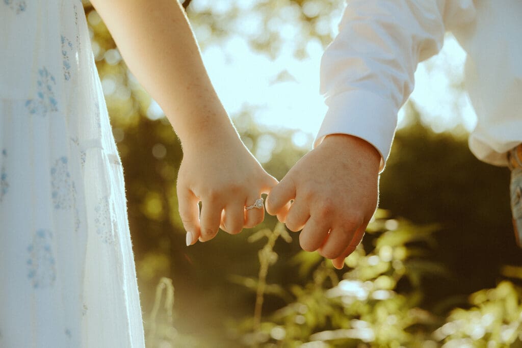 Dreamy detail image of couple holding hands in a field in Abilene, TX