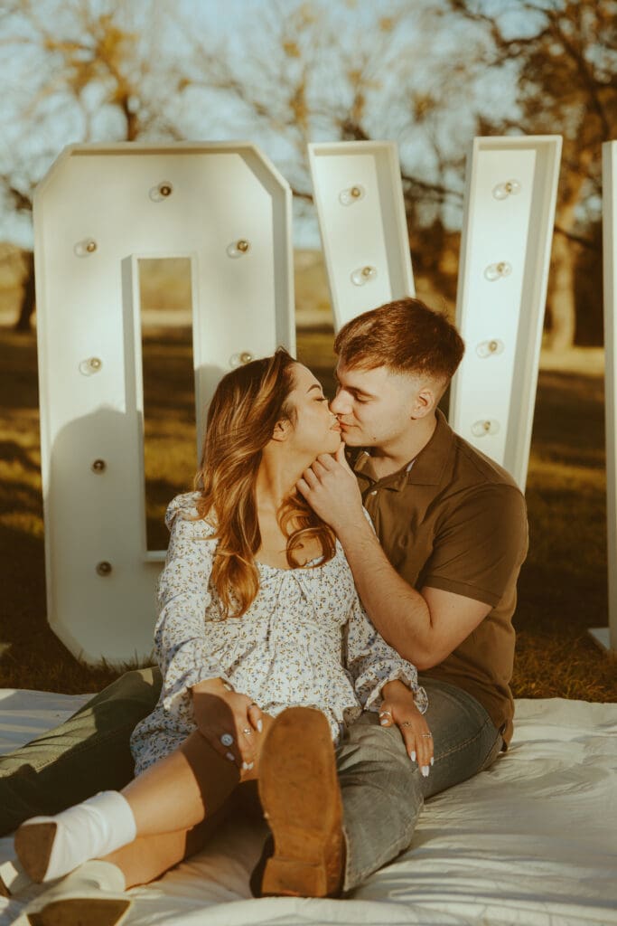 Romantic and surprise proposal with marque letters that say "LOVE" in a field in Buffalo Gap, TX