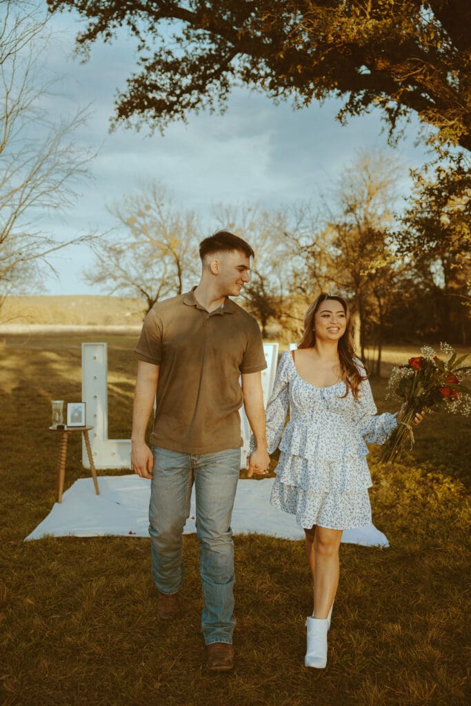 Romantic and surprise proposal with marque letters that say "LOVE" in a field in Buffalo Gap, TX