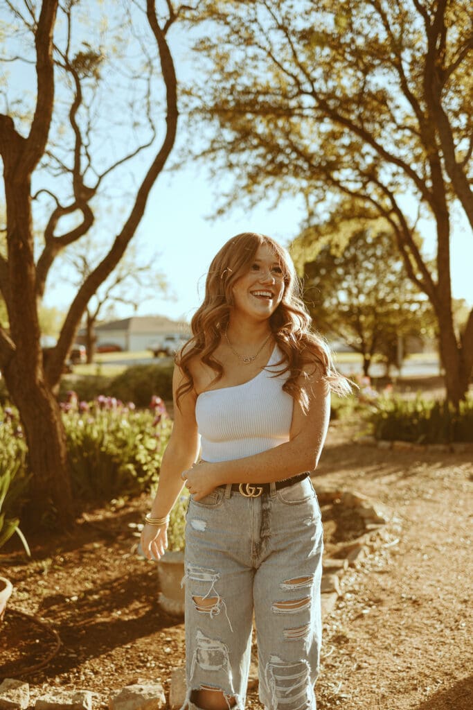 Whimsical senior session in a garden during golden hour in Abilene, TX