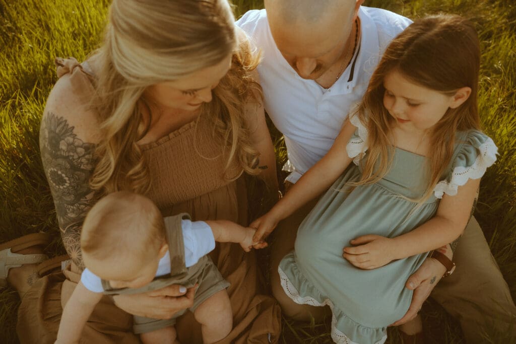 IFamily gathered together holding baby’s hand during emotional lifestyle photography session in Abilene Texas