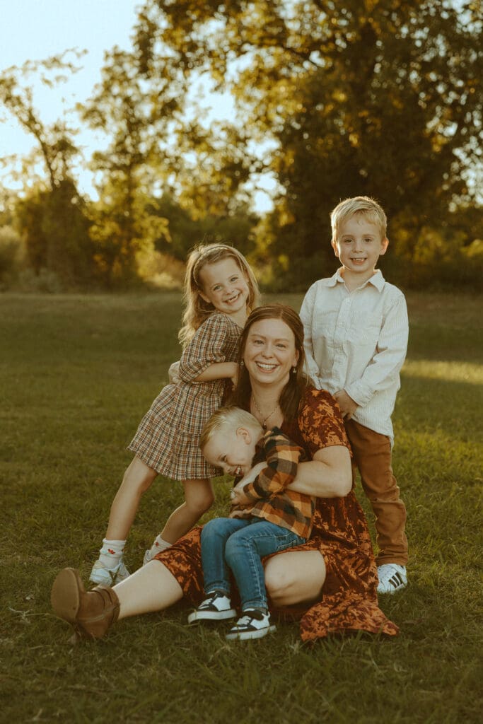 Candid family photography moment with mom and children laughing during golden hour session in Abilene Texas