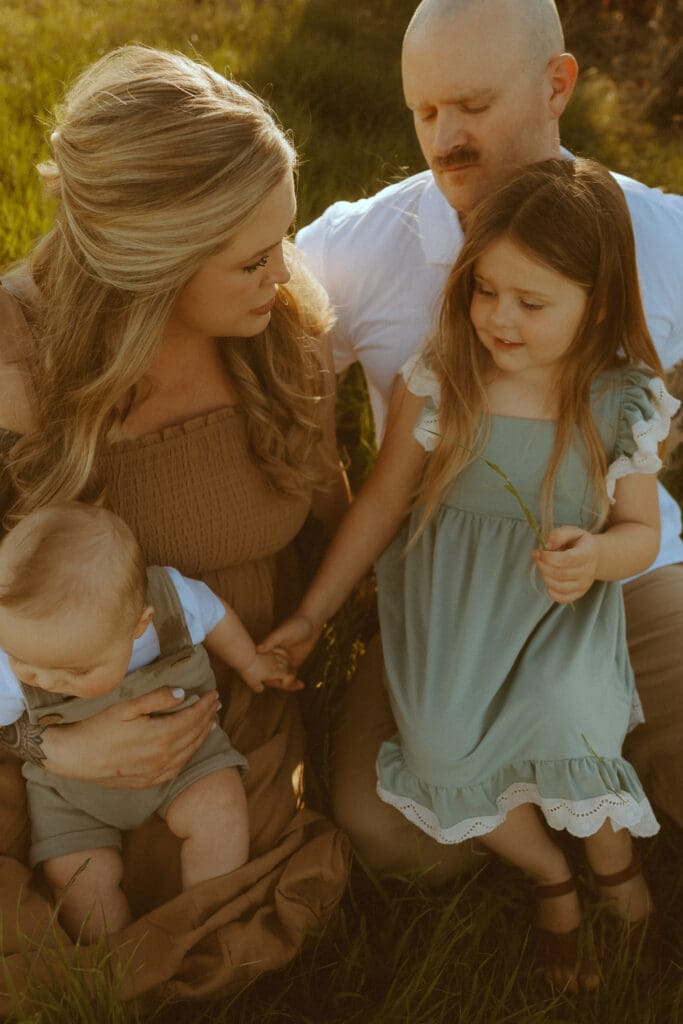 Family gathered together holding baby’s hand during emotional lifestyle photography session in Abilene Texas