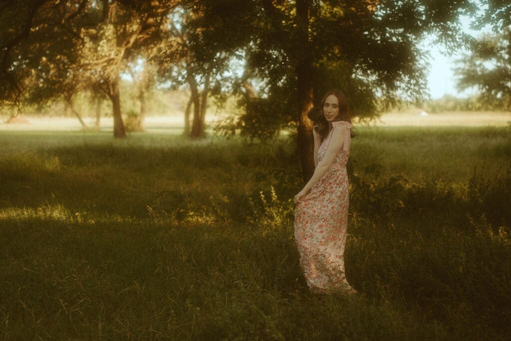 Morgan Rose standing in a golden field with her camera, reflecting the intentional and nostalgic branding style behind her photography business and creative work.