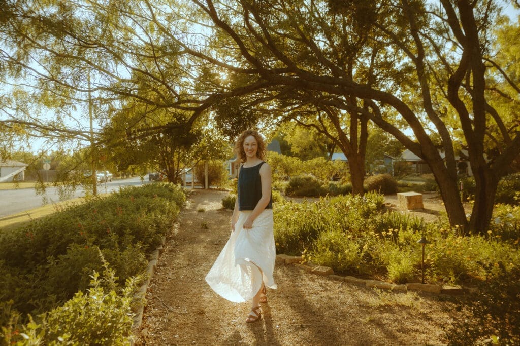 Senior portrait photographed during golden hour with warm sunlight filtering through trees in Abilene, Texas.