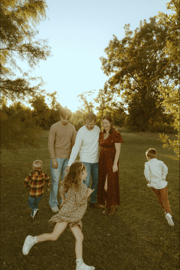 Children running around their parents during a golden hour family photography session in Abilene, Texas, capturing childhood memories through movement, play, and authentic family connection.