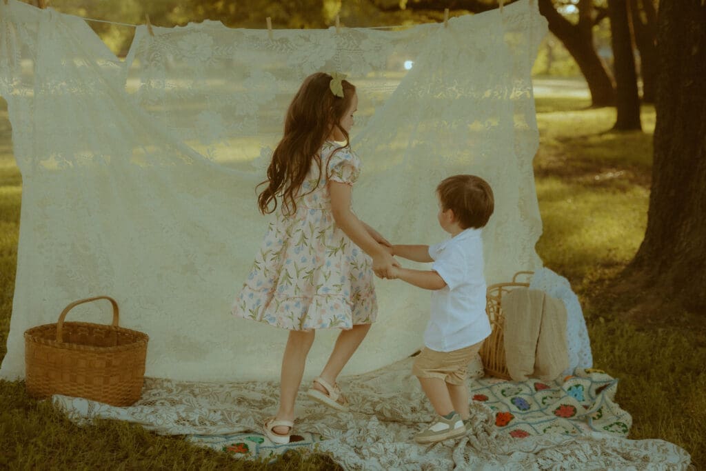 Two young siblings dancing together during a nostalgic childhood photography session in Abilene, Texas.