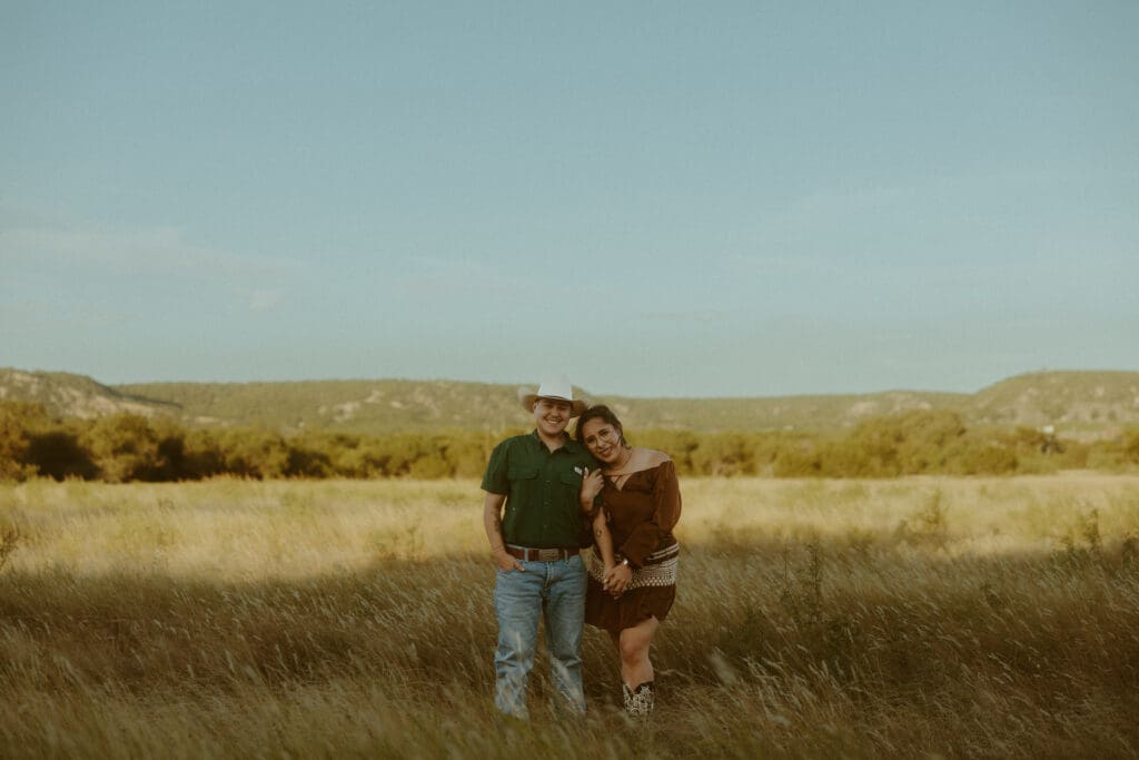 Couple standing together in a golden field during an evening photography session in Abilene, Texas.