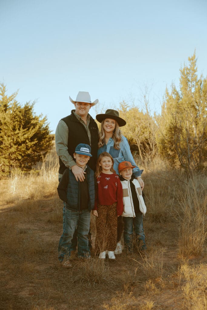 Family wearing cozy layers, earthy colors, and warm fall outfits during an outdoor photography session in Abilene, Texas.