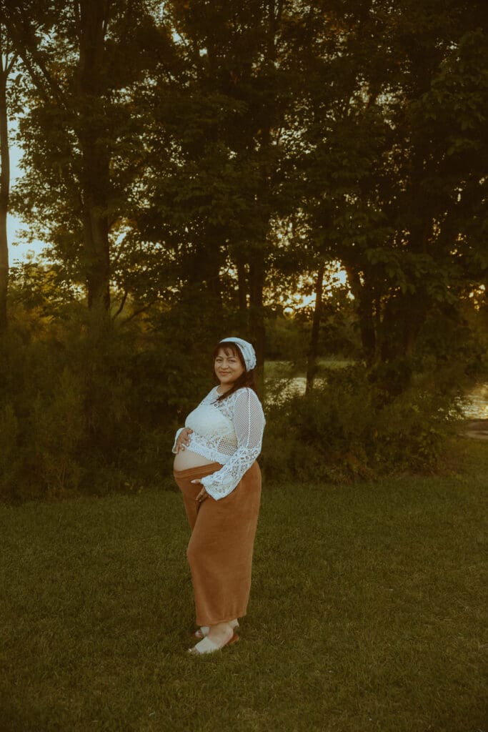 Expecting mother holding her baby bump during an outdoor maternity photography session in Abilene, TX.