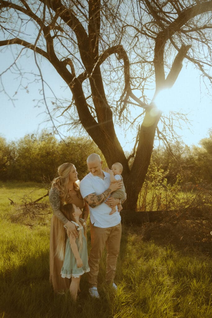 Family wearing warm brown, cream, tan, and soft sage outfits during a golden hour fall photo session in Abilene, Texas.